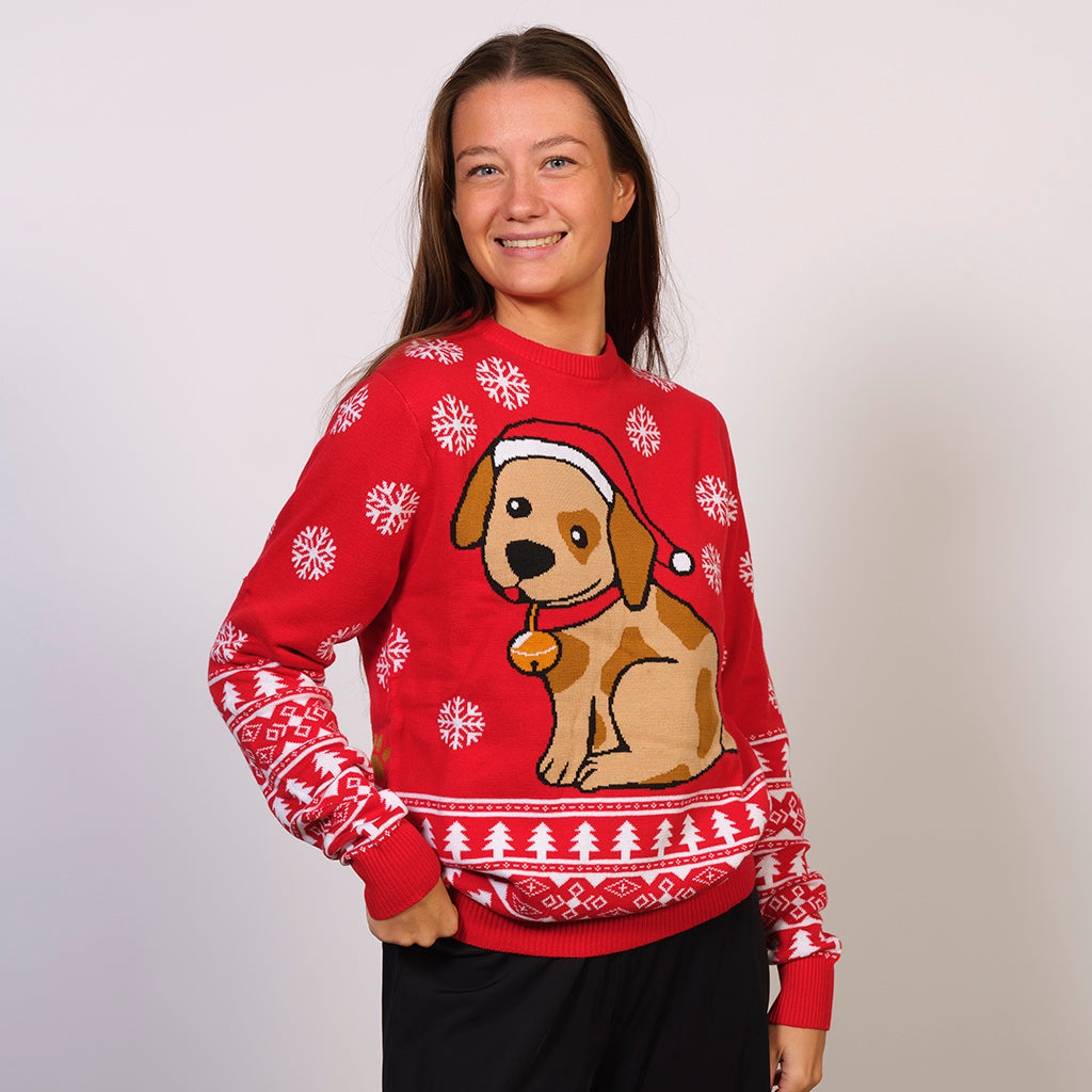 En kvinde en rød julesweater med en julehund og snefnug på.